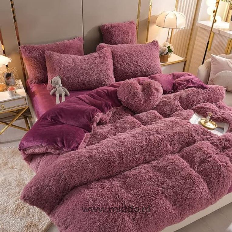 Foto van 5 set donkerroze fluffy fleece beddengoed met gratis hartjes kussen netje opgemaakt op bed met kleine grijze knuffelbeer.