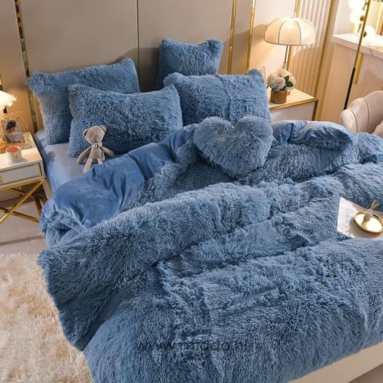 Foto van 5 set blauw fluffy fleece beddengoed met gratis hartjes kussen netje opgemaakt op bed met kleine grijze knuffelbeer.