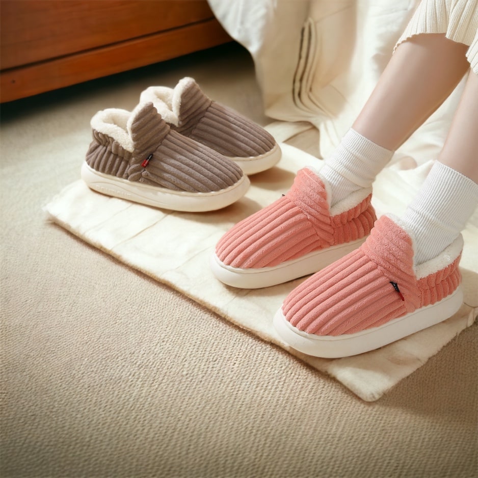 Persoon draagt roze en bruine CozyComfort pantoffels met witte fleece voering