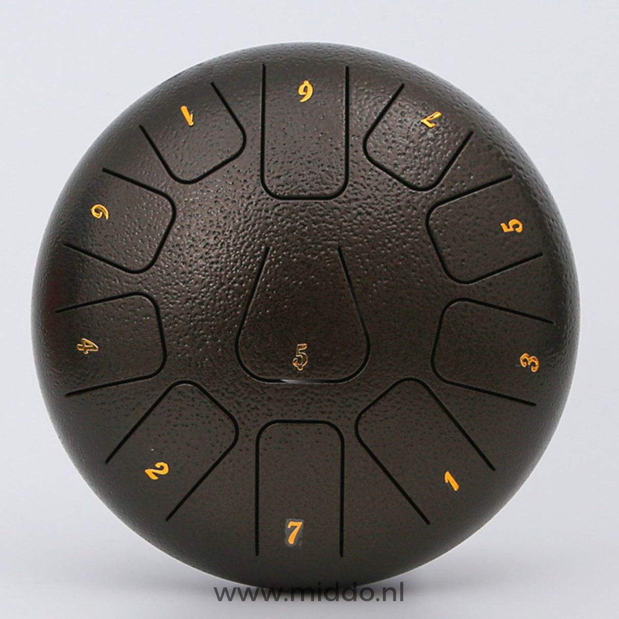 Close-up van een bronskleurige steel tongue drum met cijfers op een witte achtergrond