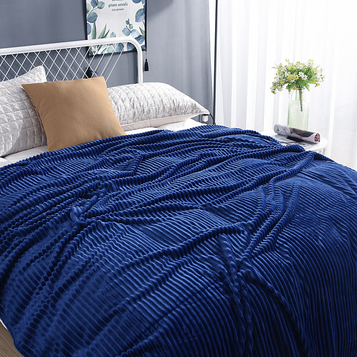 Donkerblauwe fluwelen fleece deken op een opgemaakt bed