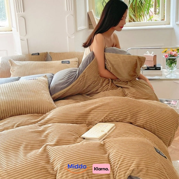 Vrouw zit op bed met beige fleece dekbedovertrek, leest boek.