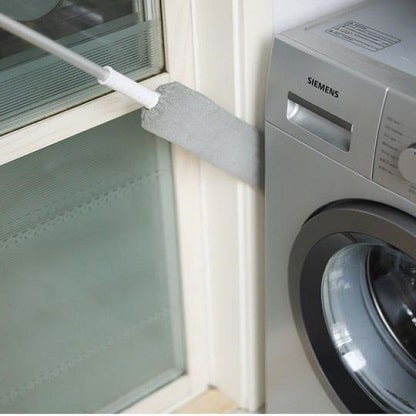 Uitschuifbare stofdoek naast wasmachine.