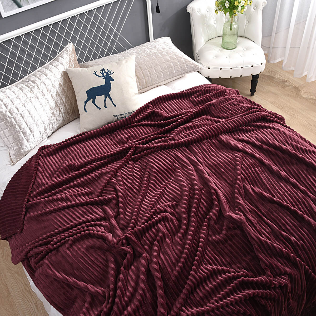 Donkerrood fluwelen fleece kleed op een bed met rendier kussen