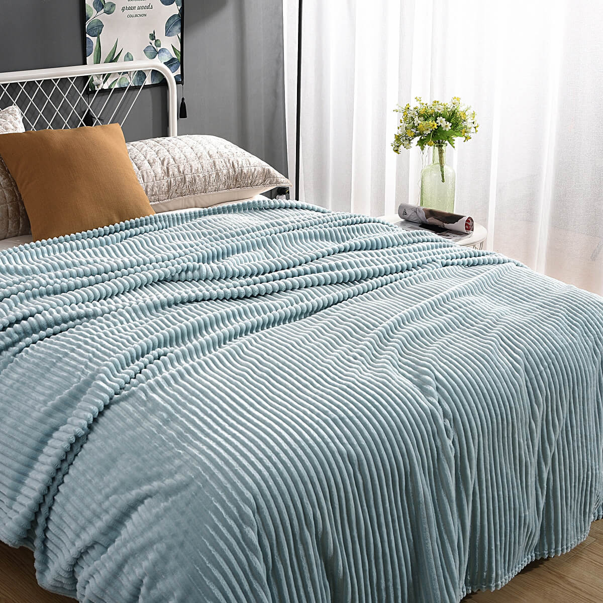 Lichtblauw fluwelen fleece kleed op een opgemaakt bed met kussen