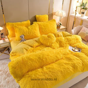 Geel 5 set fluffy fleece beddengoed met hartjes kussen netjes opgemaakt met klein berenknuffeltje op bed.