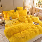 Geel 5 set fluffy fleece beddengoed met hartjes kussen netjes opgemaakt met klein berenknuffeltje op bed.