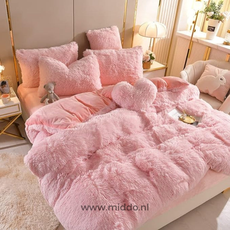 Foto van 5 set lichtroze fluffy fleece beddengoed met gratis hartjes kussen netje opgemaakt op bed met kleine grijze knuffelbeer.