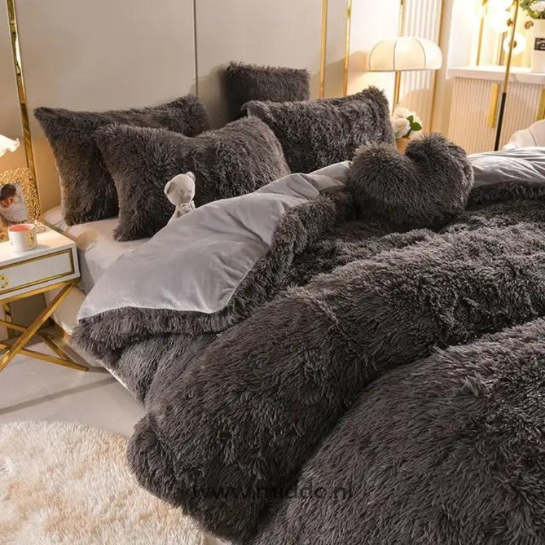 Foto van 5 set Zwart fluffy fleece beddengoed met gratis hartjes kussen netje opgemaakt op bed met kleine knuffelbeer.