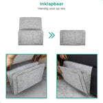 Lichtgrijze BedCaddy inklapbaar voor op reis en ook 2 kleine foto's hangend aan een bank.