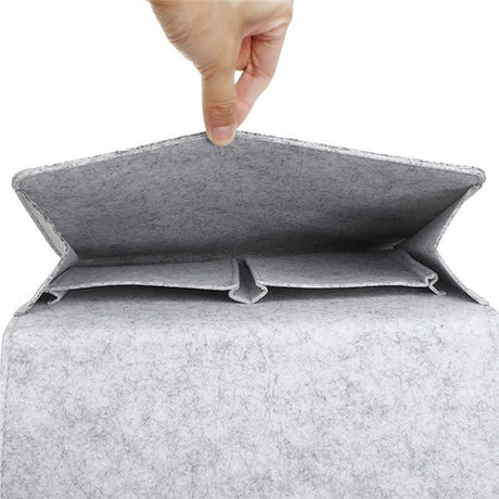 Een hand houd de lichtgrijze BedCaddy open zodat je kunt zien hoe het ervan binnen uitziet.