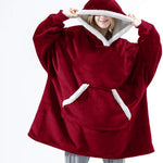 Persoon draagt een rode Sherpa Fleece XXL hoodie met witte rand.