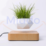 Witte zwevende pot met groen gras op lichtbruine basis.