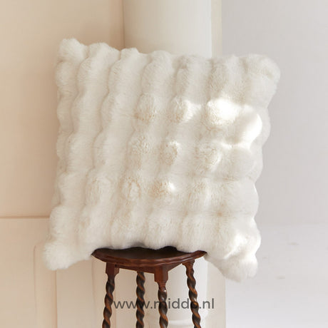 Fluffy kussen met decoratieve textuur op een kruk