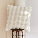 Fluffy kussen met decoratieve textuur op een kruk
