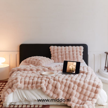 Roze Fluffy Toscaanse winterdeken op bed met laptop en kussen