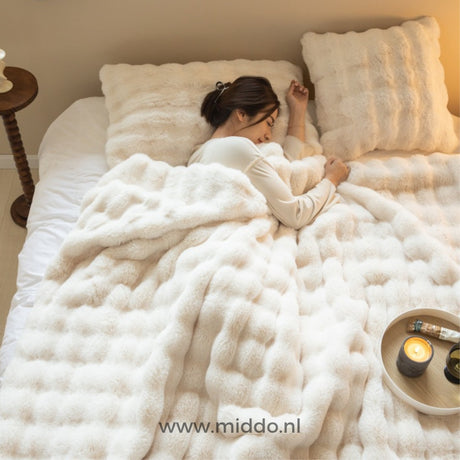 Persoon slaapt onder Fluffy Toscaanse winterdeken in beige slaapkamer