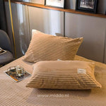 2 kussens met beige kussenslopen op een bed