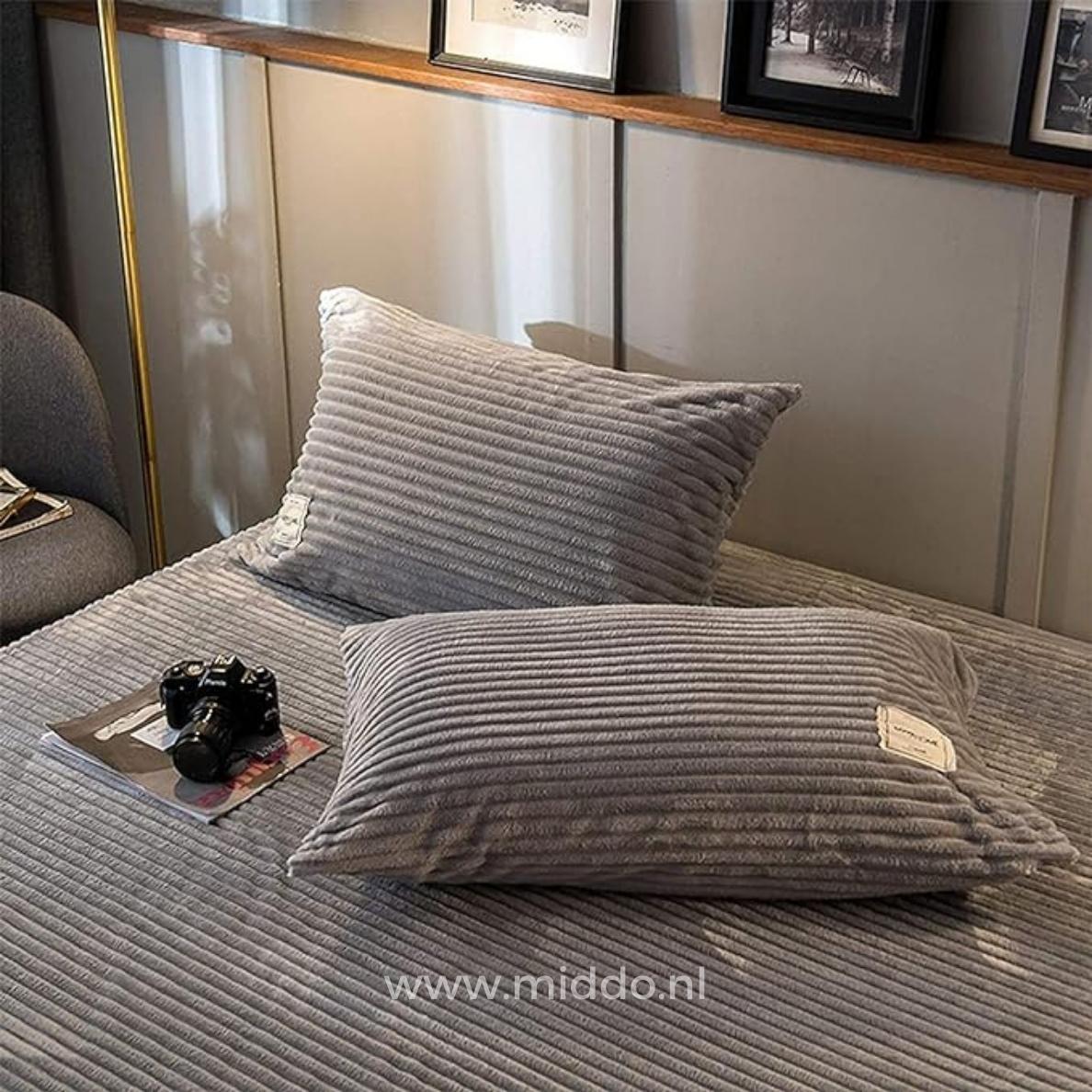 2 kussens met grijze kussenslopen op een bed