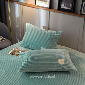 2 kussens met jadegroene kussenslopen op een bed