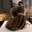 Vrouw op bed die een bruin fluwelen fleece dekbedovertrek met ribstructuur en donkere bies tegen zich aan houdt