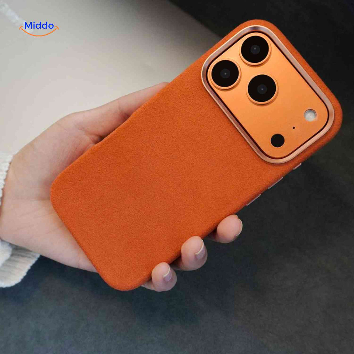 Hand met oranje iphone hoesje met getextureerde grip en camera bescherming www.middo.nl