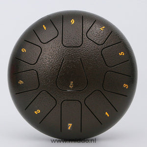 Close-up van een bronskleurige steel tongue drum met cijfers op een witte achtergrond