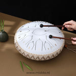 Handen bespelen een witte Harmonii KlankOase Steel Tongue Drum met mallets