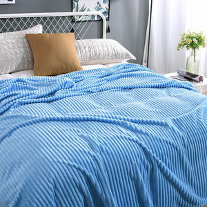 Lichtblauwe fluwelen fleece deken op een opgemaakt bed