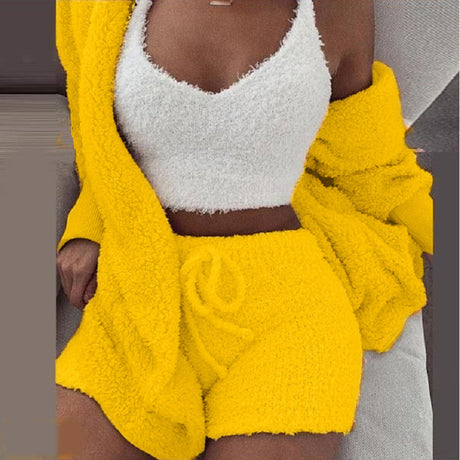 Vrouw in gele SheCutie comfy set met short, top en vest op grijze achtergrond