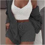 Vrouw in grijze SheCutie comfy set met short, top en vest zittend op bank