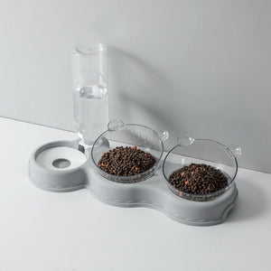 Grijze voedertray met waterdispenser en voerbakken.