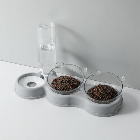 Grijze voedertray met waterdispenser en voerbakken.