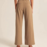 Deze dame showt de achterkant van de bruine Wijdepantalon met 2 achterzakken.