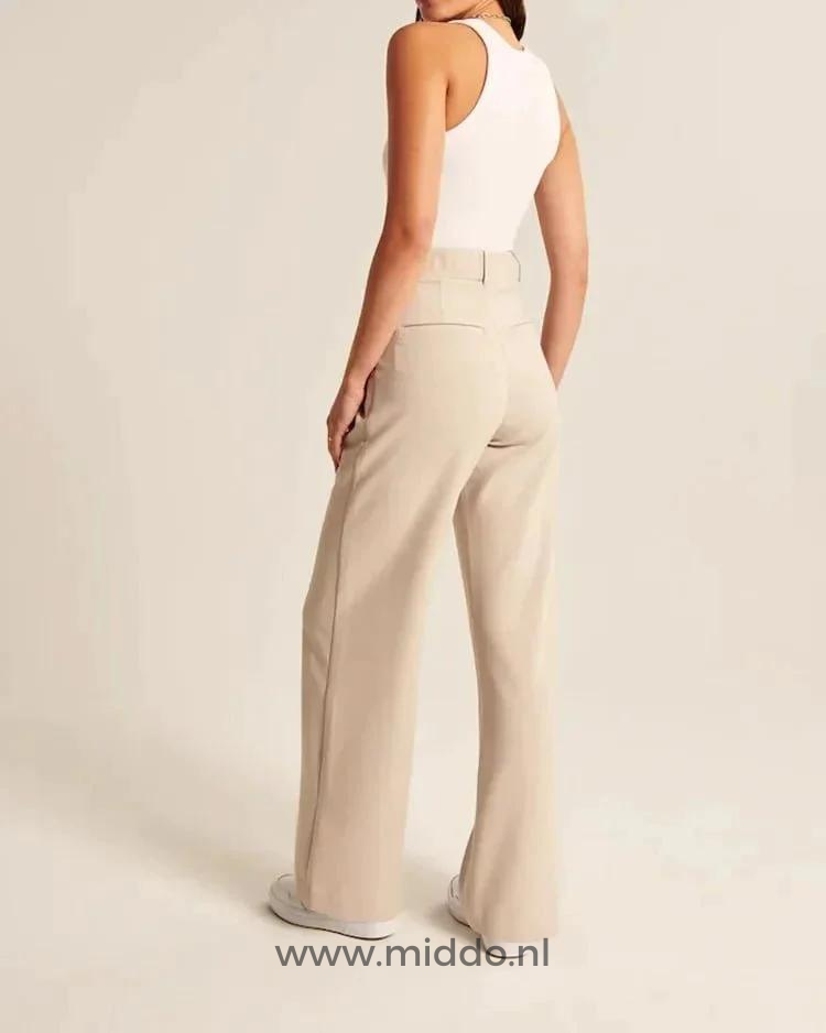 Vrouw showt de achterkant van de wijde pantalon beige