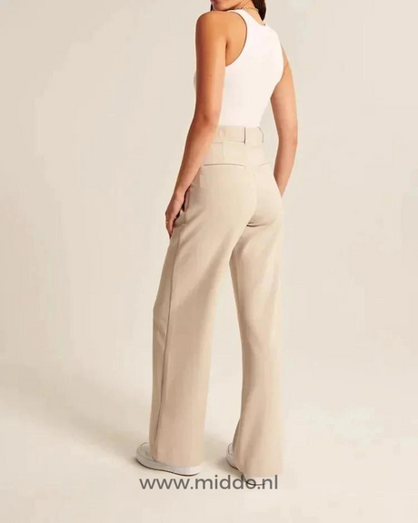 Vrouw showt de achterkant van de wijde pantalon beige