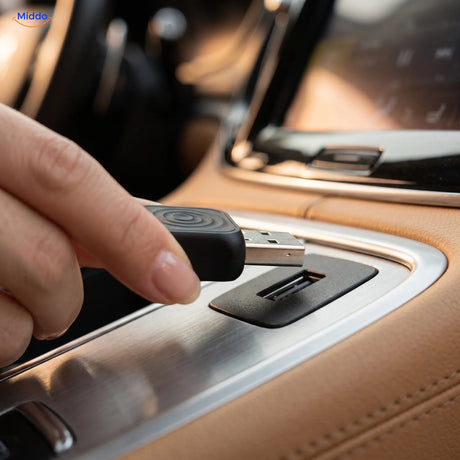 Hand steekt de CarLink Pro adapter in de USB-poort van de middenconsole