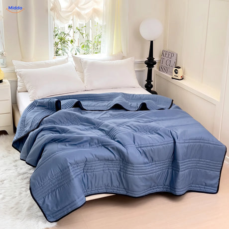 Coolwave koeldeken in de kleur donkerblauw op een opgemaakt bed