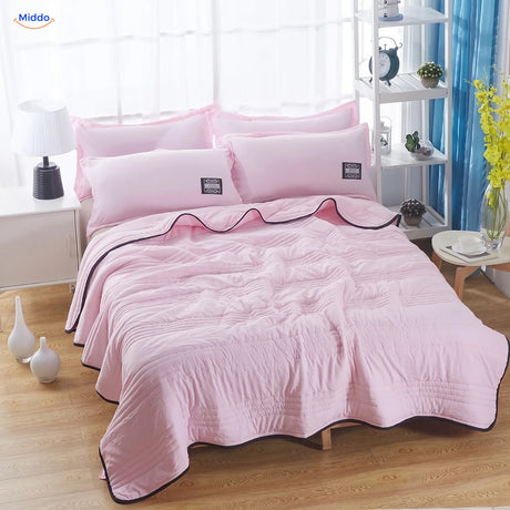 Coolwave koeldeken in de kleur roze op een opgemaakt bed