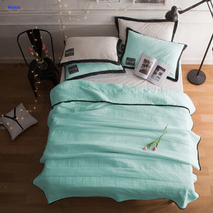 Coolwave koeldeken in de kleur water groen op een opgemaakt bed
