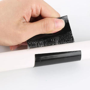 Hand die zwarte watervaste tape op een pijp aanbrengt.
