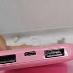 Close-up van Huggy's roze powerbank-aansluitingen.