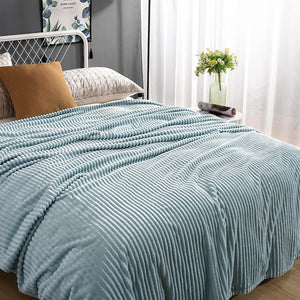 Lichtblauw fluwelen fleece kleed op een opgemaakt bed met kussen