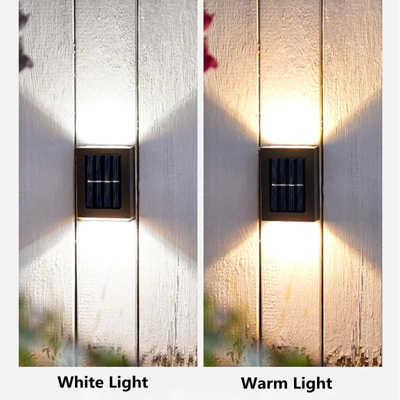 Twee buitenlampen met wit en warm licht tegen een houten muur.