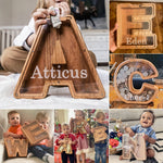 Kinderen met verschillende houten alfabet spaarpotten.