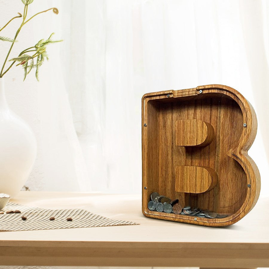 Houten spaarpot in de vorm van letter B gevuld met munten.