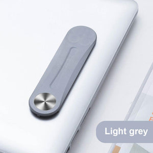 Grijze magnetische clip bevestigd aan een laptop.