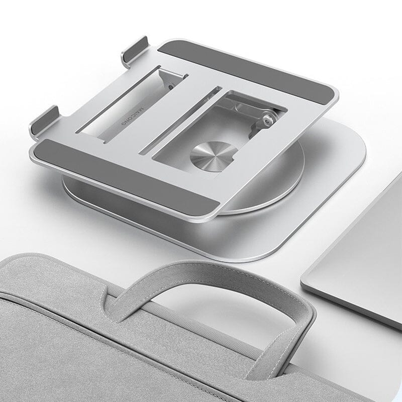 Opvouwbare laptopstandaard naast tas en laptop op wit oppervlak.