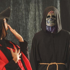 Halloween skeletmasker met zichtbaar brein en nek gedragen onder zwarte monnikskap met touwriem