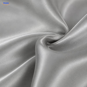 Close-up van de gladde zilvergrijze polyester satijnstructuur van Silkora